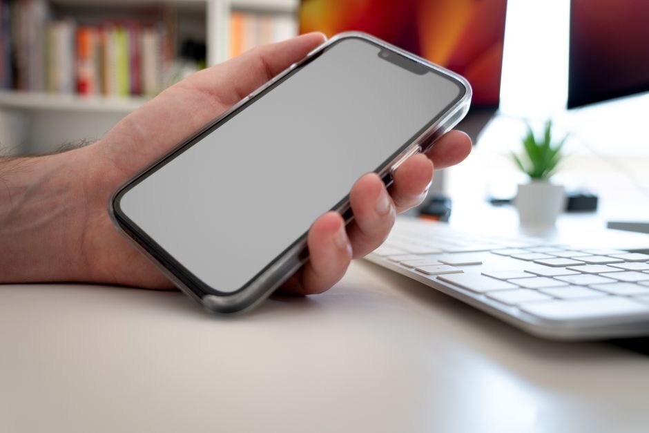Mano sosteniendo un movil con un mensaje recibido en la pantalla